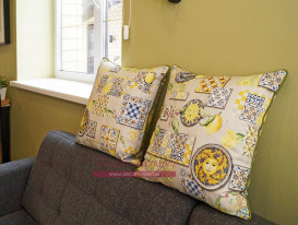 Две декоративные подушки с тонким оливковым кантом в гостиной коттеджа.