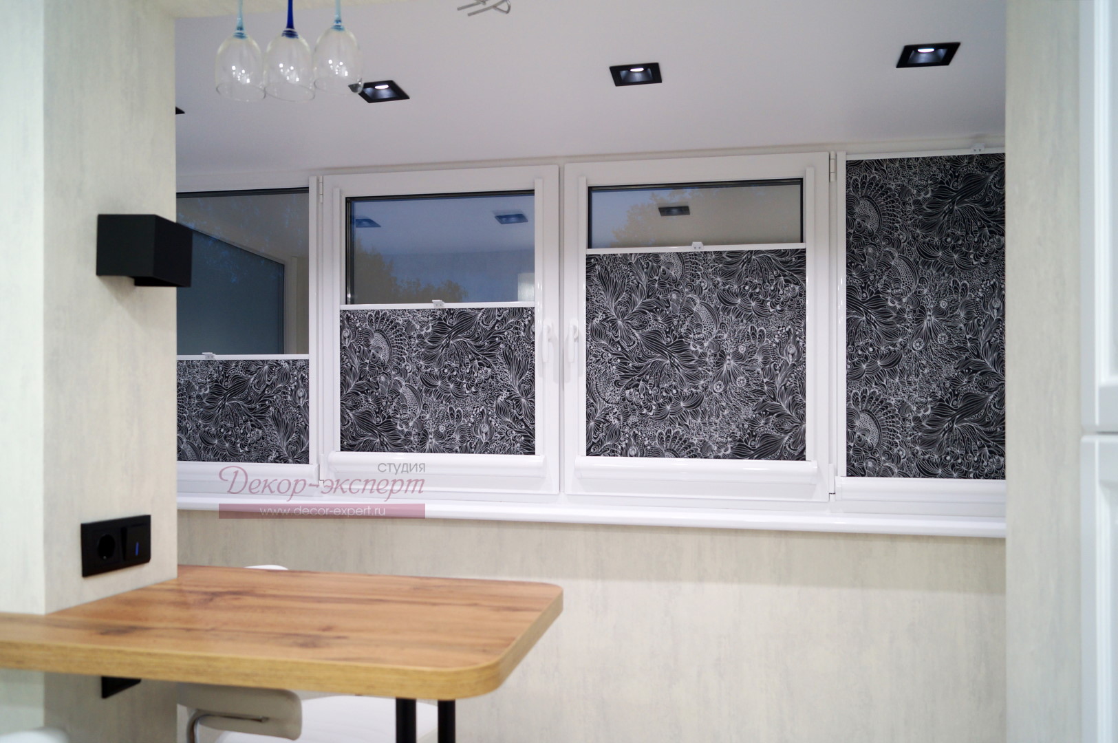 Фрагмент интерьера кухни с рулонными шторами на окне.