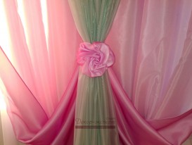 Декоративная розочка в точке крепления подхватов розовых драпировок.