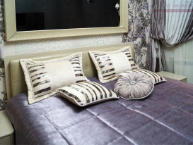 Декоративные подушки на покрывале в сиреневой спальне в стиле Роберто Ковалли.