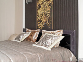 Декоративные подушки на покрывале в спальне в стиле Роберто Кавалли.