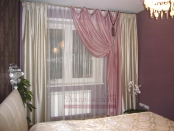 Розовая драпировка с провисами в сочетании с белыми портьерами в спальне.