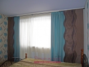 Статичные японские шторы с фигурным краем в комбинации с бирюзовыми портьерами в спальне.