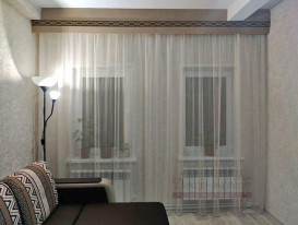 Тюль и гладкий ламбрекен с отделкой декоративным кантом в гостиной под сложным потолком с балками.