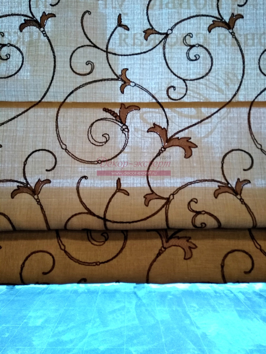 Фрагмент римской шторы для окна в пекарне из ткани с вышивкой.